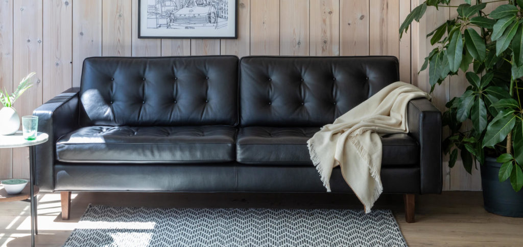 Hepburn Black Leather Sofa in a wood panelled room