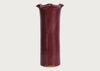 A tall, flared ceramic vase with a glossy deep burgundy glaze, shown against a plain light gray background.