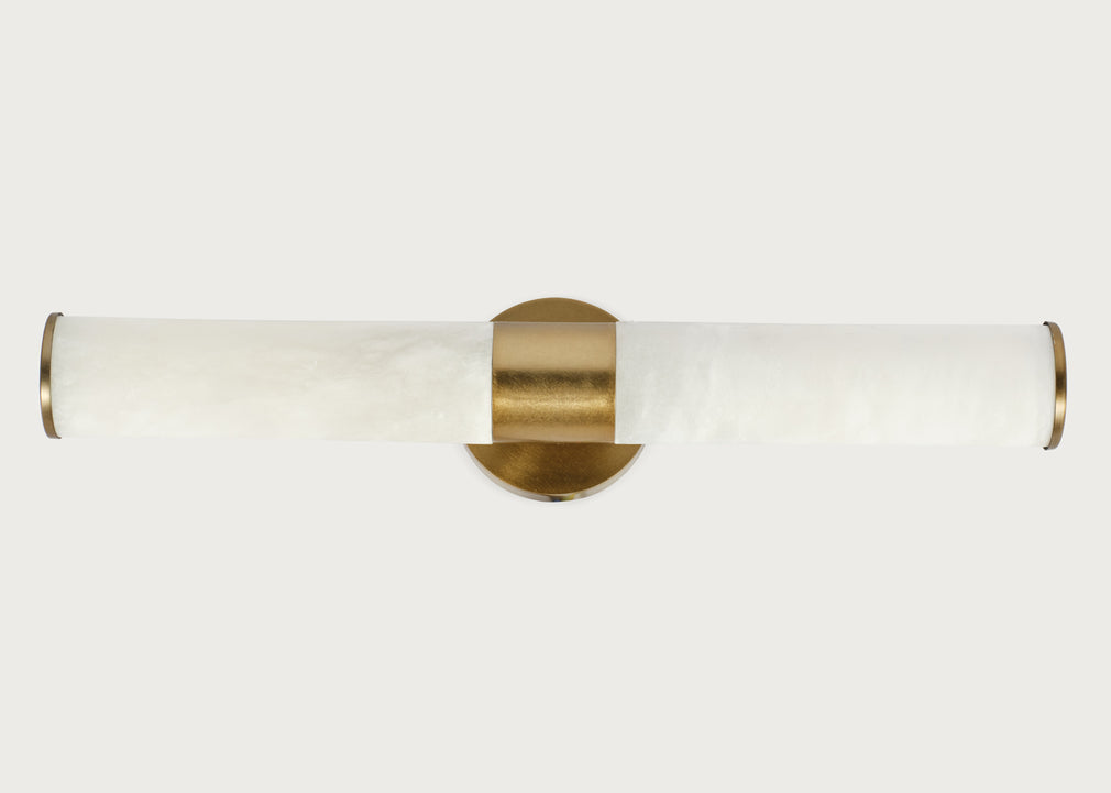 A modern wall-mounted light fixture with a cylindrical white marble shade and brushed brass hardware, shown against a light gray background.