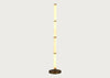 A modern floor lamp with a tall, cylindrical column made of stacked warm-toned alabaster sections, flanked by two slim vertical white panels, and resting on a round dark metal base against a light gray background.