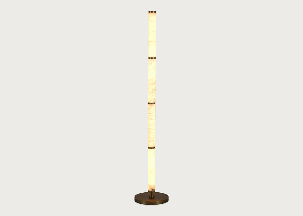 A modern floor lamp with a tall, cylindrical column made of stacked warm-toned alabaster sections, flanked by two slim vertical white panels, and resting on a round dark metal base against a light gray background.