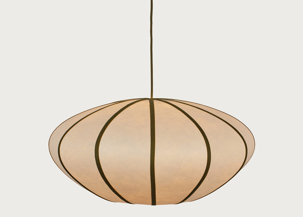 A modern pendant light with a large, rounded, disc-like shade made of warm beige paper or fabric panels divided by dark brown vertical stripes, suspended by a thin dark cord against a light gray background.
