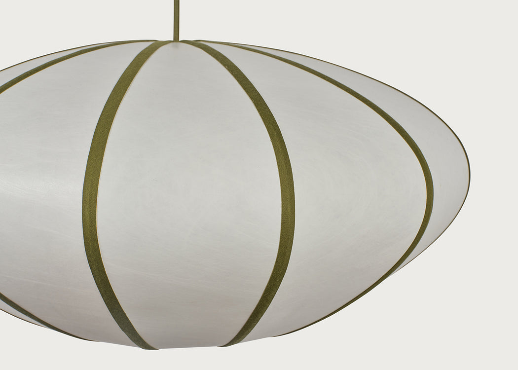 A close-up of a modern pendant light with a white or off-white ribbed shade and olive green vertical bands, suspended by a matching cord against a light gray background.