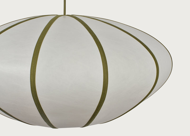 A close-up of a modern pendant light with a white or off-white ribbed shade and olive green vertical bands, suspended by a matching cord against a light gray background.
