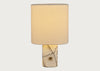 A table lamp with a cylindrical white fabric shade and a polished cream-colored stone base featuring natural dark veining and a small central brass accent, shown against a light gray background.
