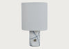 A table lamp with a cylindrical white fabric shade and a white marble base featuring dark veining and a small brass accent.