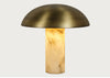 A mushroom-shaped table lamp with a brushed brass dome shade and a glowing warm alabaster stone column base, shown against a light gray background.