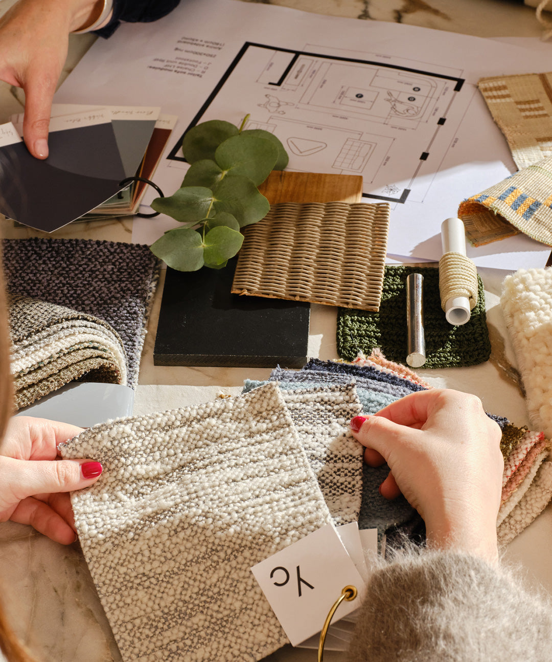 Heal's Interior Design Service two people moodboarding with fabric swatches and floorplans