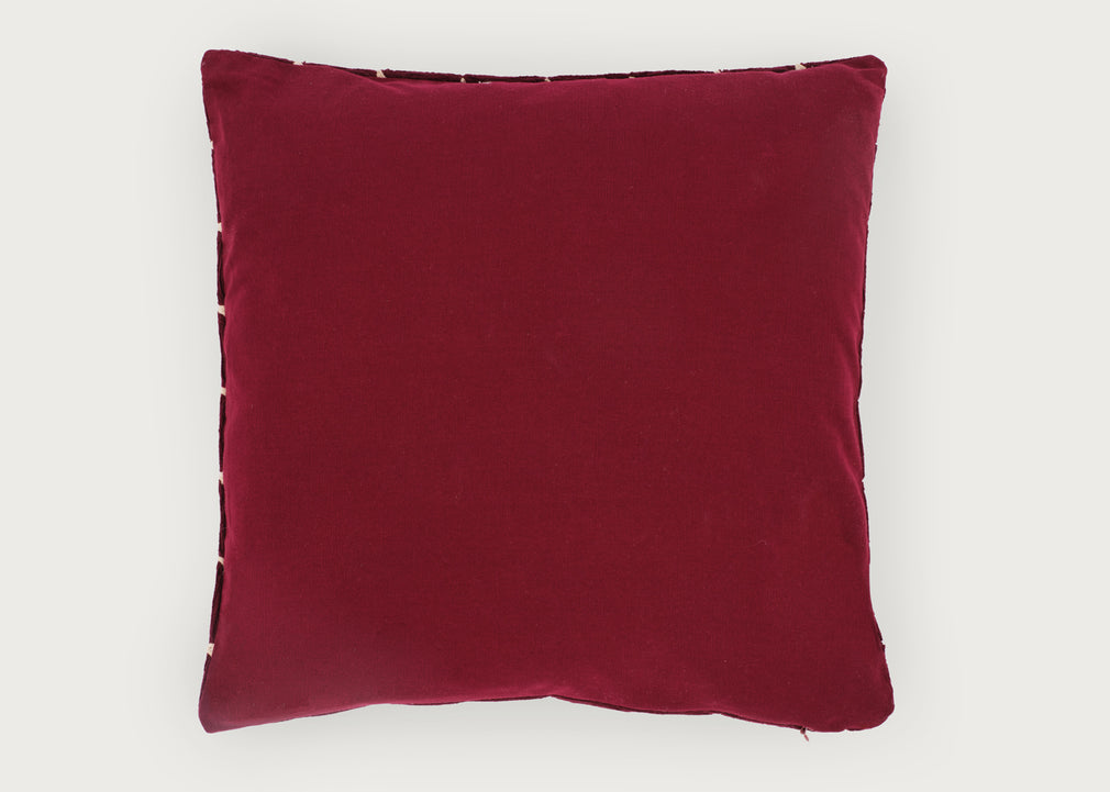 A square deep burgundy velvet throw pillow with decorative metallic trim along the edges, shown against a plain light gray background.