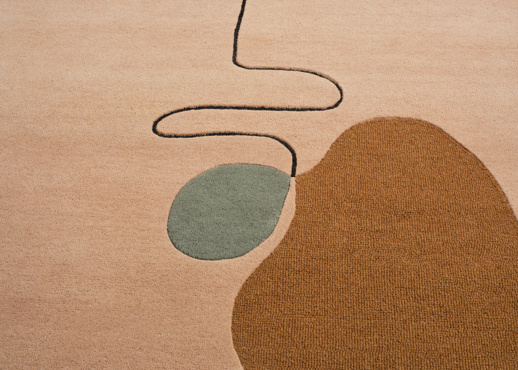 Abstract area rug with a warm beige base, a large organic brown shape, a muted sage green oval, and a thin black wavy line detail.